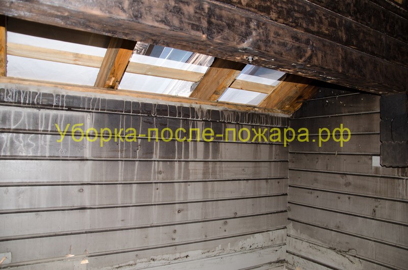 Комната в деревянной бане из профилированного бруса после пожара, на стенах копоть, сажа, видны подтеки гари